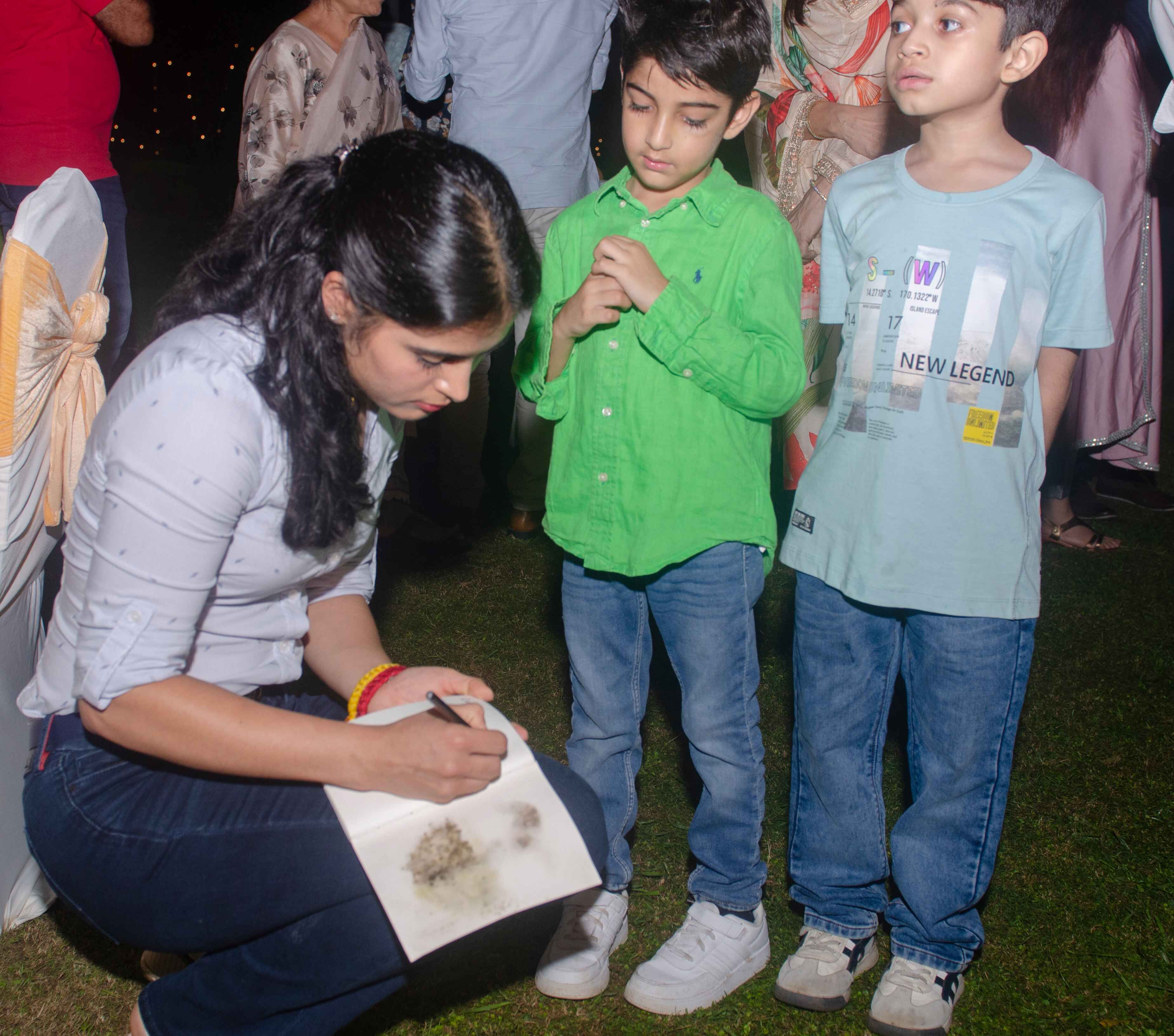 Manu Bhaker giving autographs to children during the felicitation ceremony